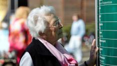 Ältere Dame vor einem Klinikschild, Alzheimer, Demenz, Seniore